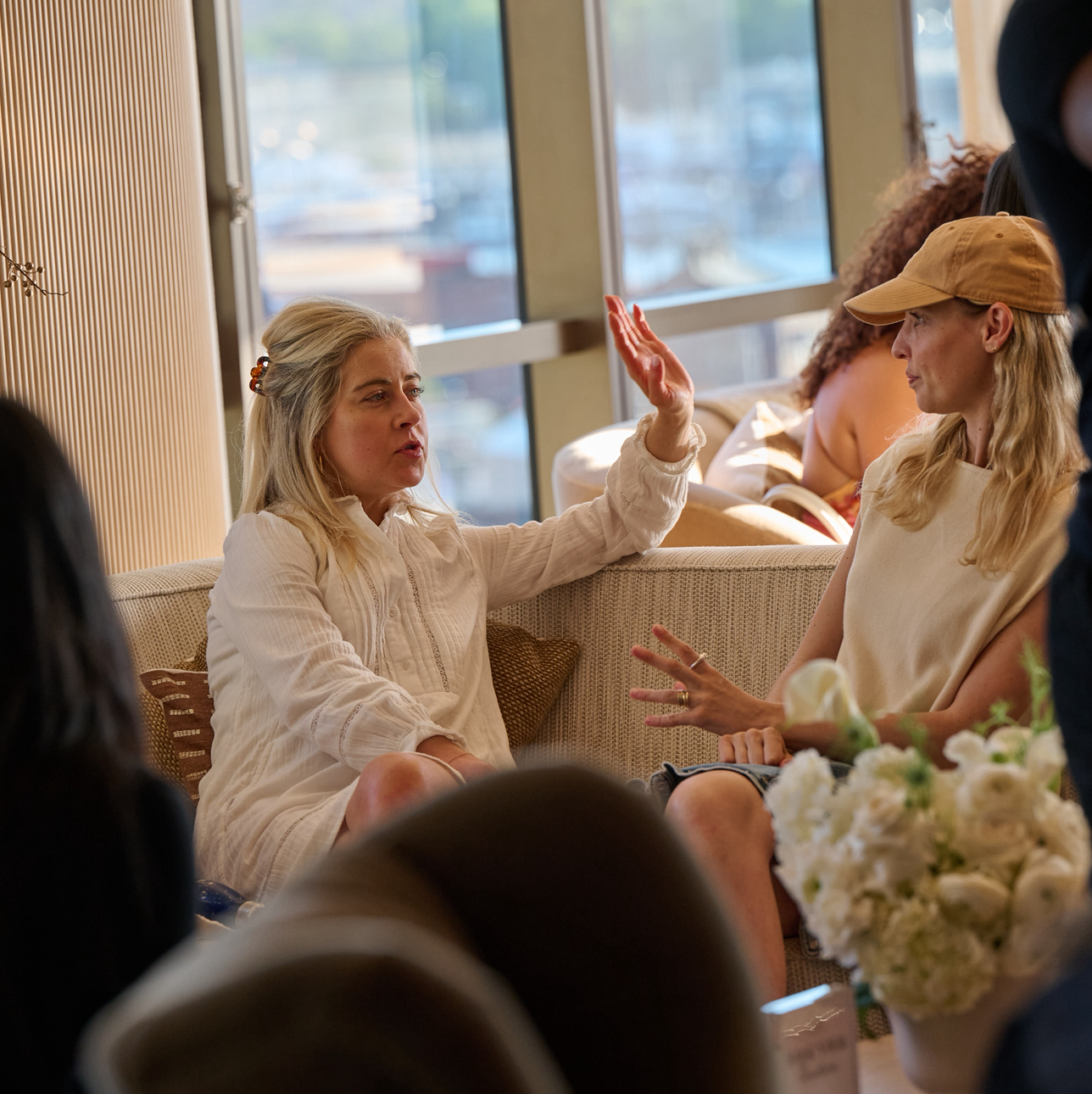 Two women in conversation, one with her hand raised during the masterclass