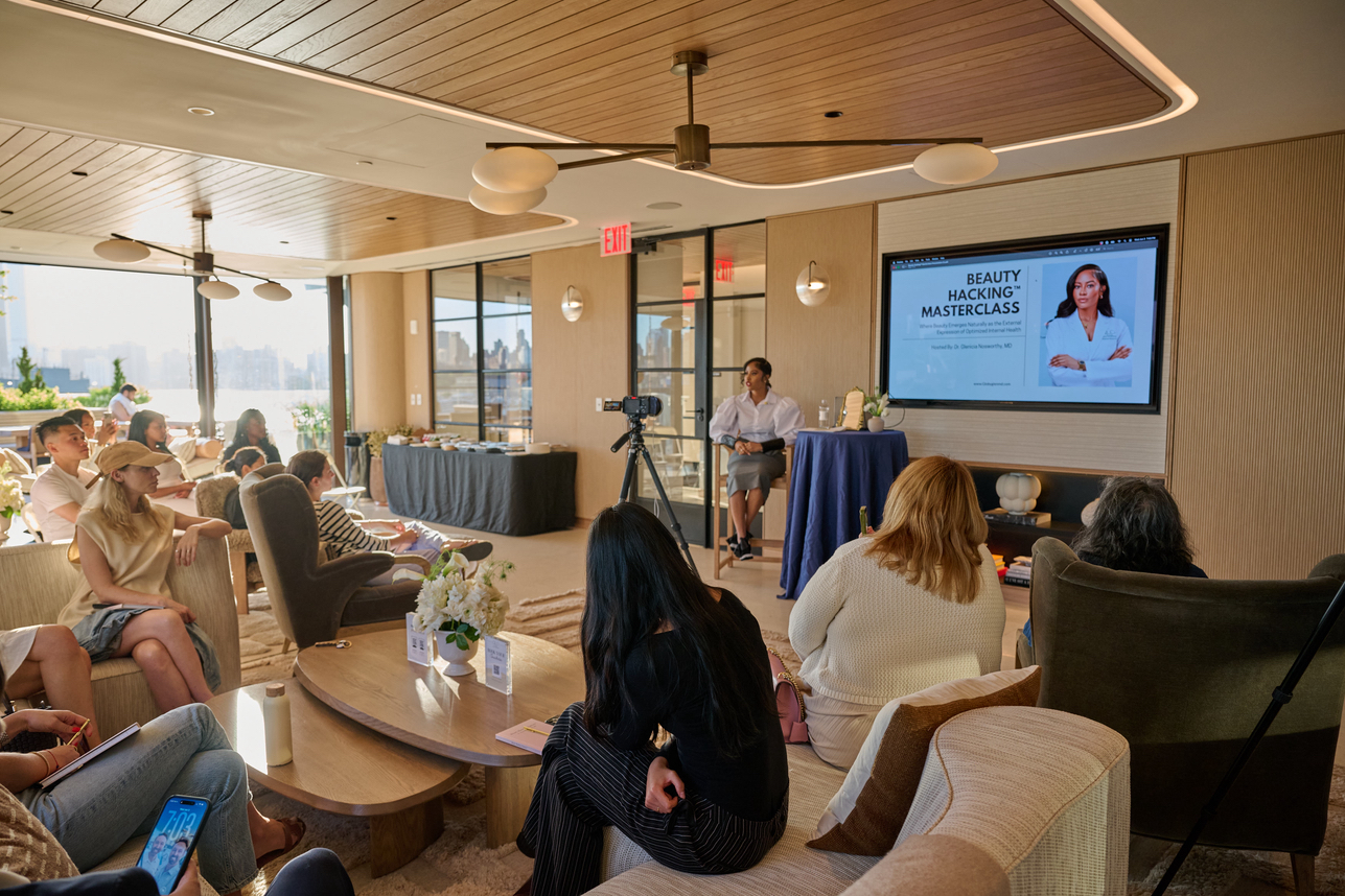 Wide shot of the full masterclass room with Dr. Glenicia presenting on screen