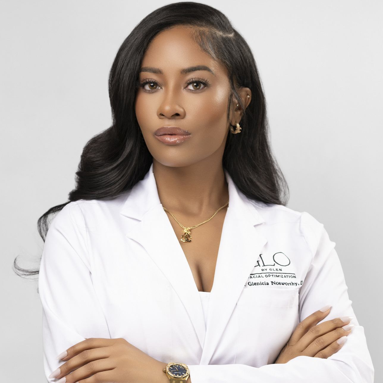 Dr. Glenicia Nosworthy, MD, in white lab coat with arms crossed, professional physician portrait