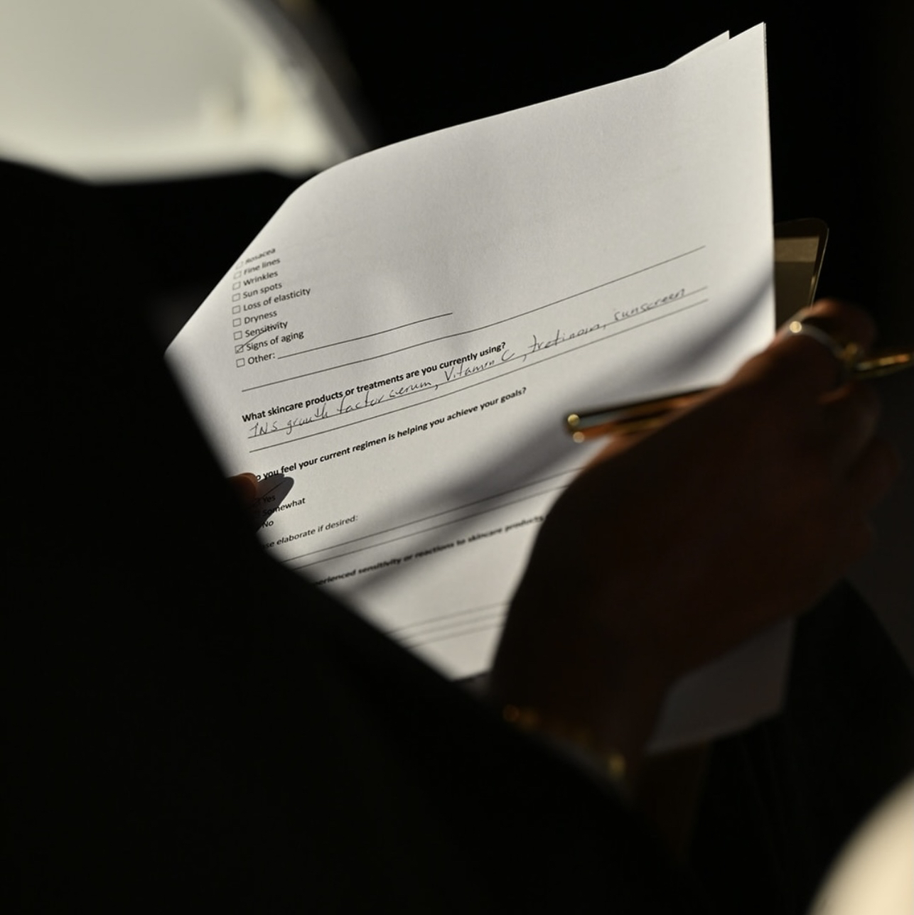 Attendee filling out a skincare intake form on a clipboard