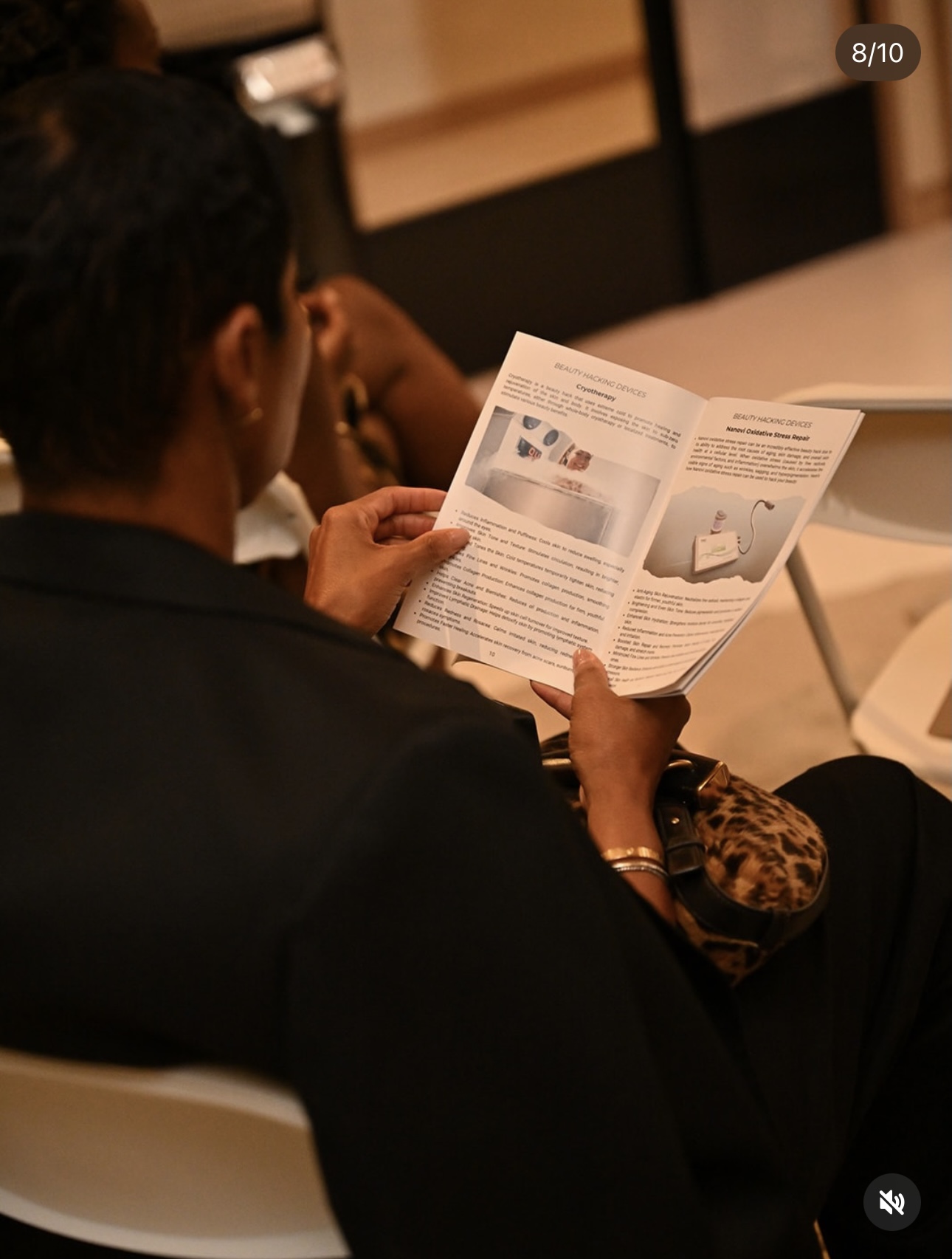 Attendee reading a Beauty Hacking Devices booklet at a masterclass event